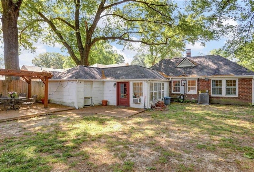 Expansive backyard featuring a pergola-covered patio, a secondary patio area, and mature trees providing natural shade.   (fyi-A/C was left in that widow after the cental hvac was installed)