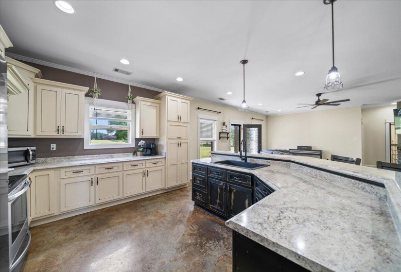 Spacious kitchen featuring an expansive island with a built-in sink and a breakfast bar