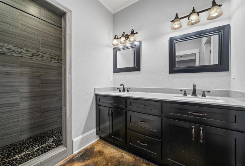 Double vanity with integrated sinks, dark wood cabinetry, and framed mirrors