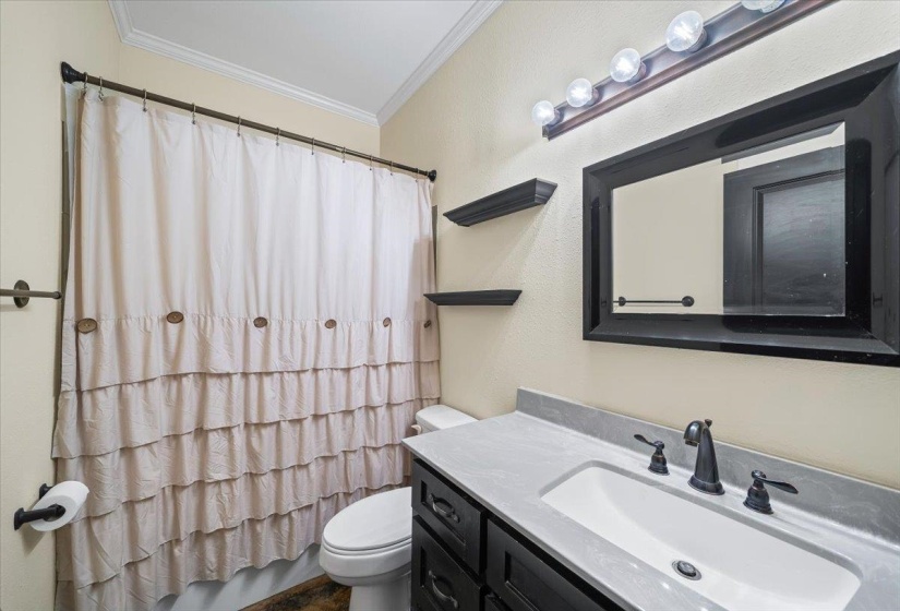Bathroom vanity with a rectangular undermount sink, dark cabinetry, and a light-toned countertop