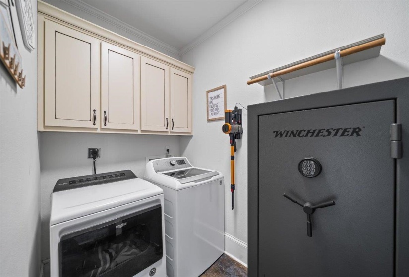 Laundry area featuring light-toned cabinetry with dark hardware and a built-in wall shelf with a wooden rod