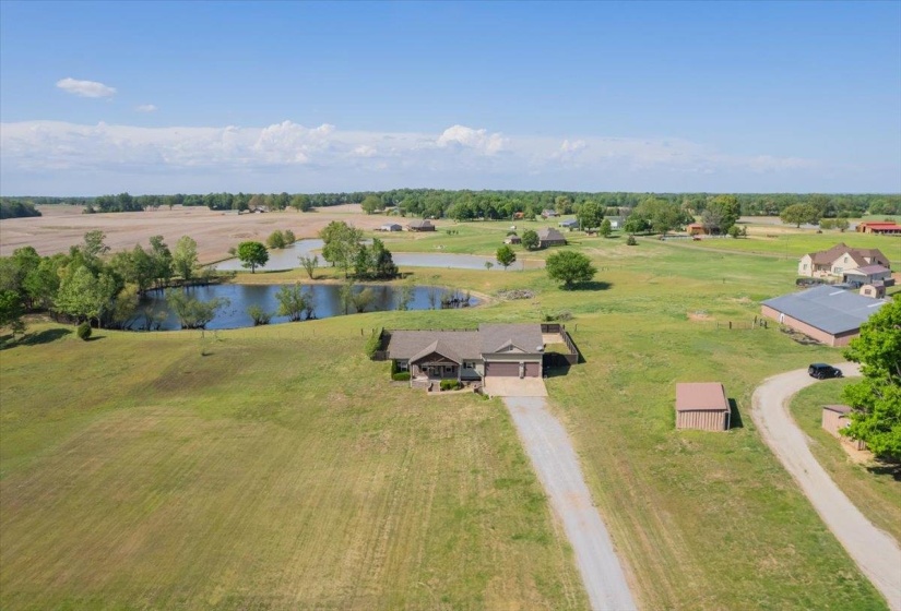 Expansive rural property featuring a main residence with an attached garage, and a fenced pool area