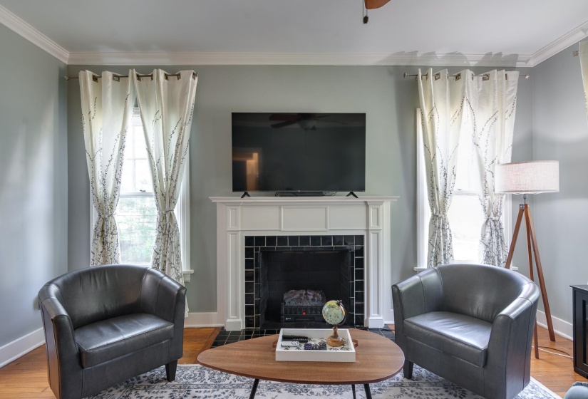 Living area featuring a fireplace with a white mantel and black tile surround