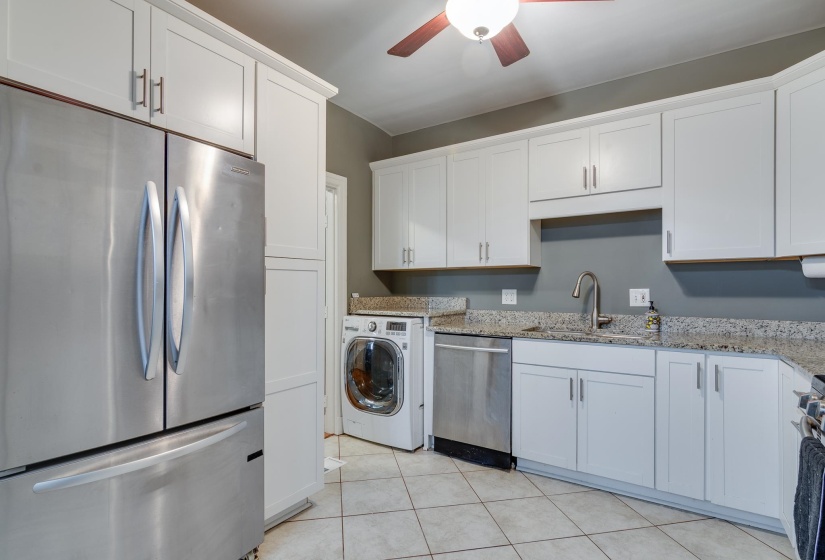 Kitchen featuring stainless steel appliances, white cabinetry, speckled countertops, and tile flooring
