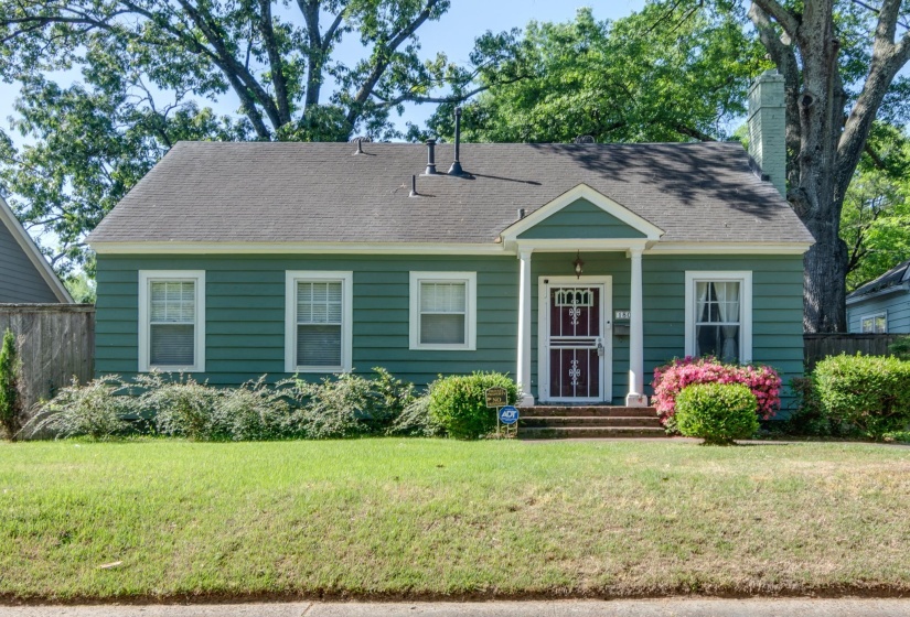 Green siding exterior with a dark red front door featuring decorative security screen