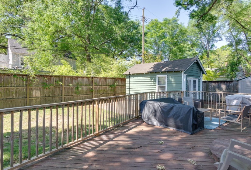 Spacious wooden deck featuring a perimeter railing, overlooking a fenced yard
