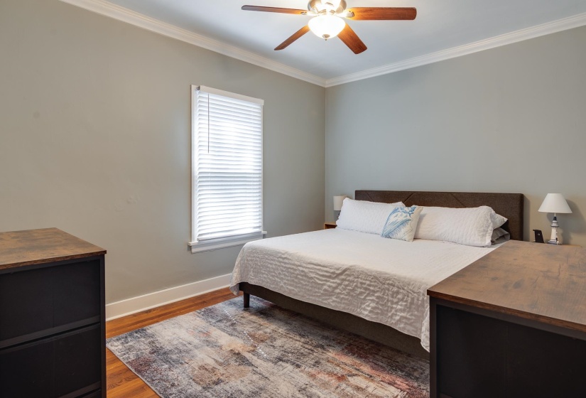 Wood-finish flooring with crisp white baseboards and crown molding