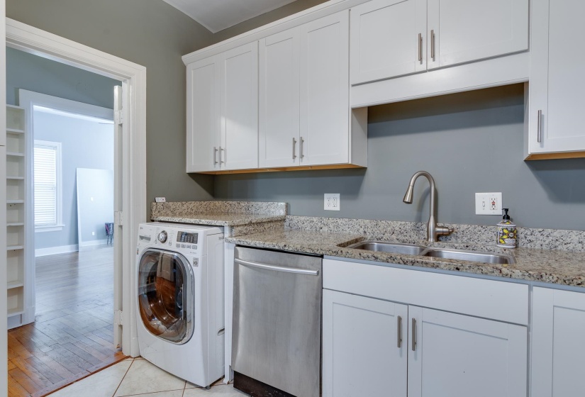 Kitchenette featuring white cabinetry, a double basin sink with a gooseneck faucet, light granite countertops, and stainless steel dishwasher