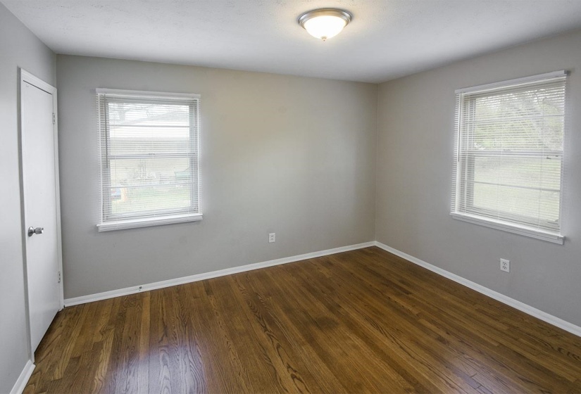 Unfurnished room featuring baseboards and dark wood-type flooring