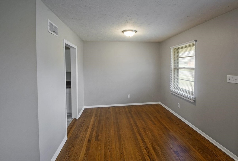 Unfurnished room with dark wood-type flooring and a textured ceiling