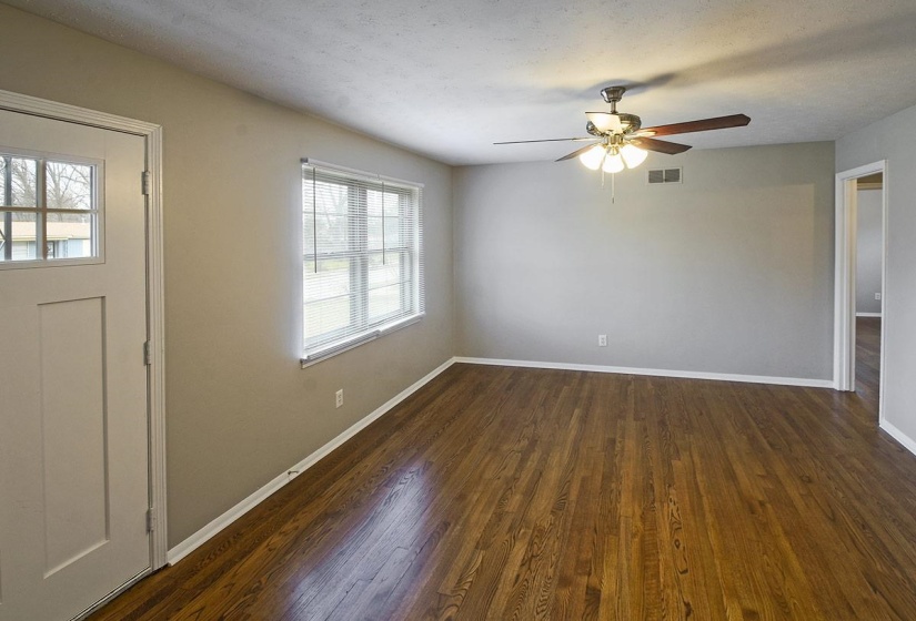 Entrance foyer with dark wood-type flooring, a textured ceiling, and ceiling fan