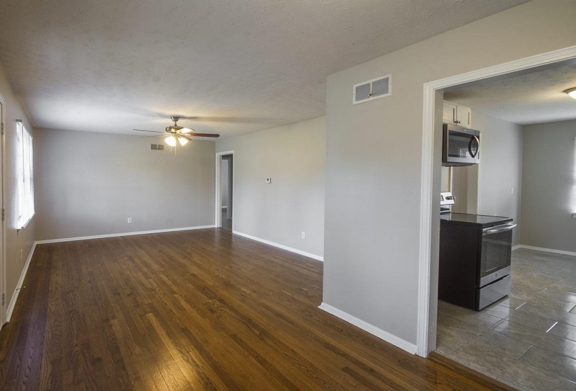 Unfurnished room featuring dark wood-style flooring, a textured ceiling, and ceiling fan
