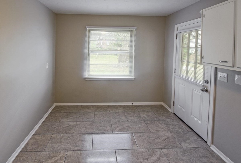 Doorway with baseboards and tile patterned floors
