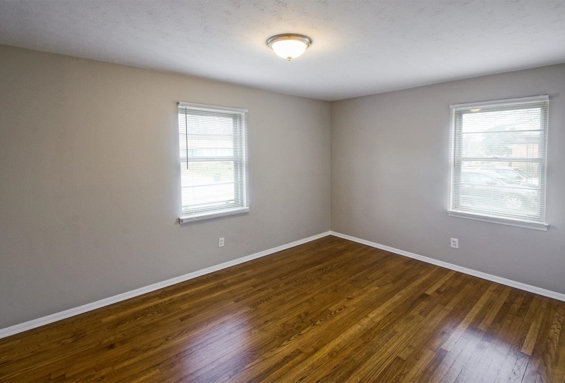 Empty room with dark wood finished floors and a textured ceiling