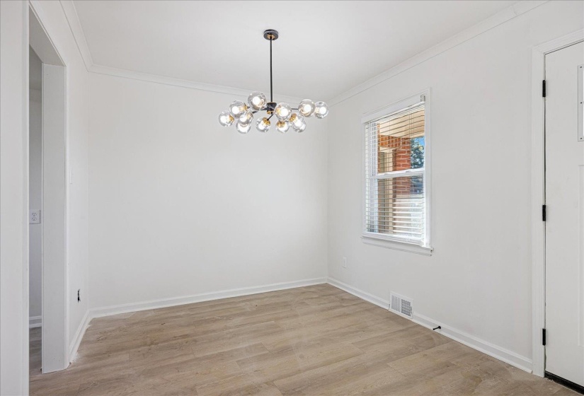 Room featuring wood-finish flooring, a contemporary chandelier, white trim, and a window with blinds