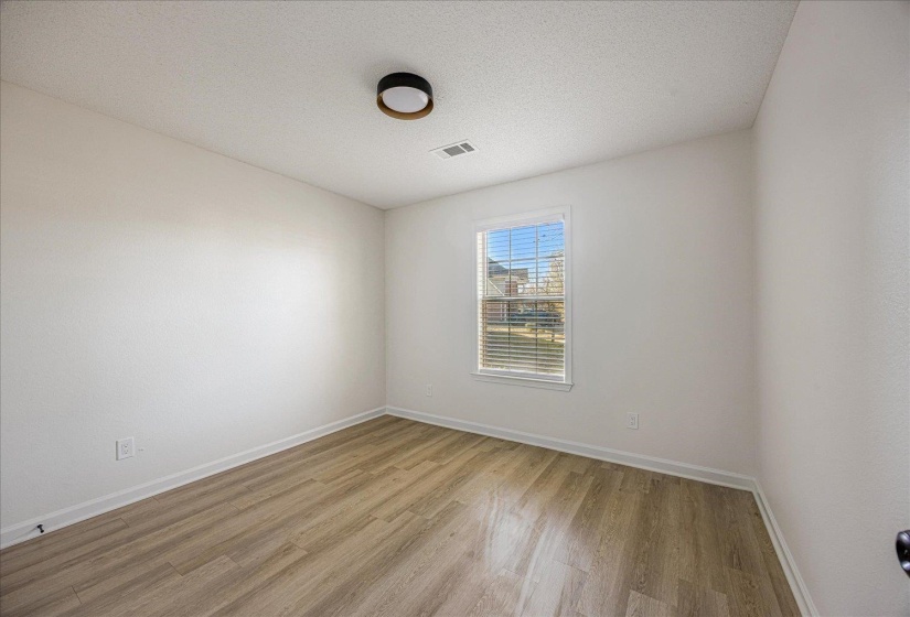 Room featuring wood-finish flooring, white baseboards, and neutral wall paint