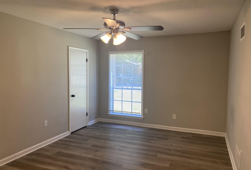 Interior room featuring wood-finish flooring, a ceiling fan with integrated lighting, and neutral wall tones