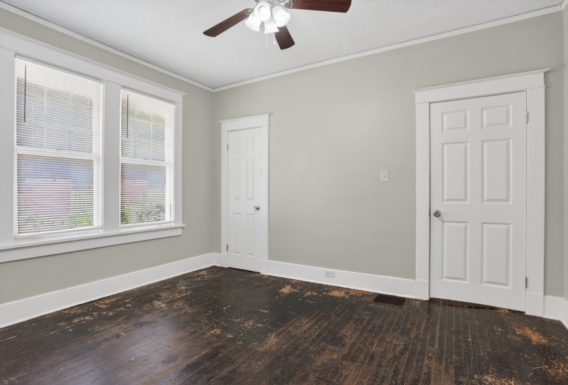 Room with wood-finish flooring, two large windows, painted walls, and white trim