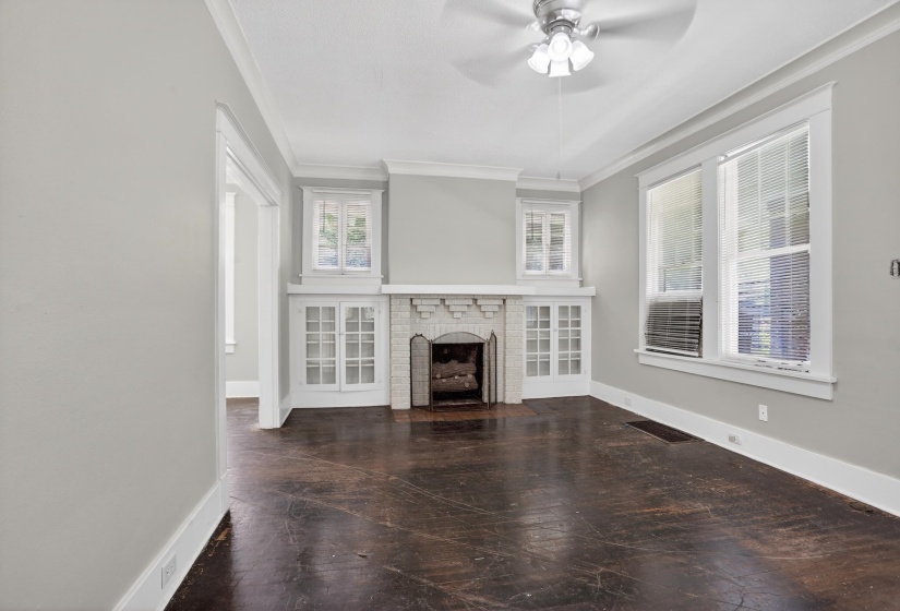 Living area featuring dark wood-finish flooring, light grey painted walls, white trim, and crown molding