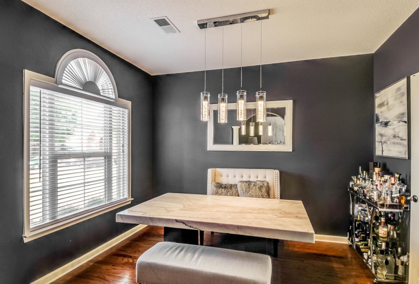 Dining area featuring dark-painted walls and wood-finish flooring