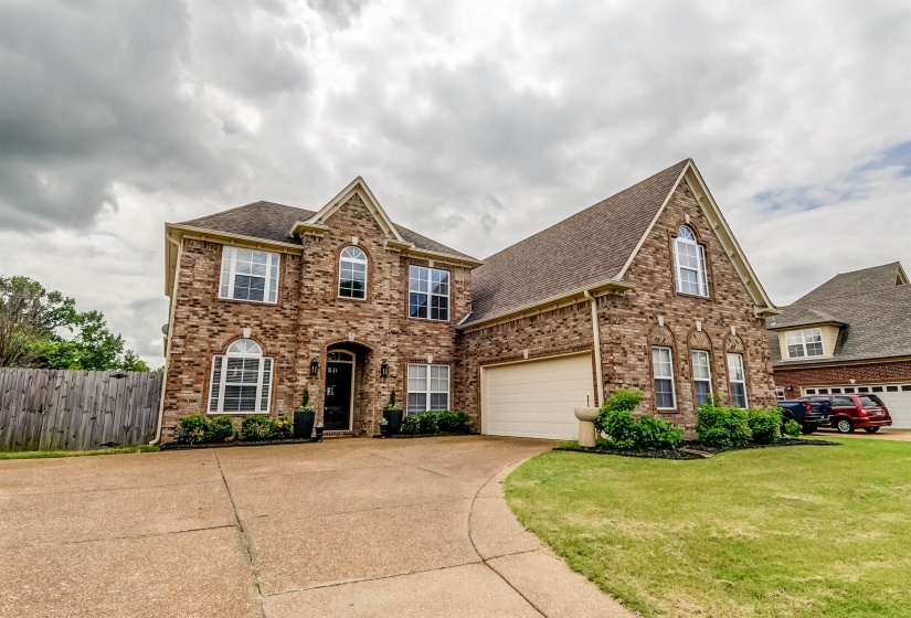 Brick exterior featuring multiple gables, arched windows, and a two-car garage