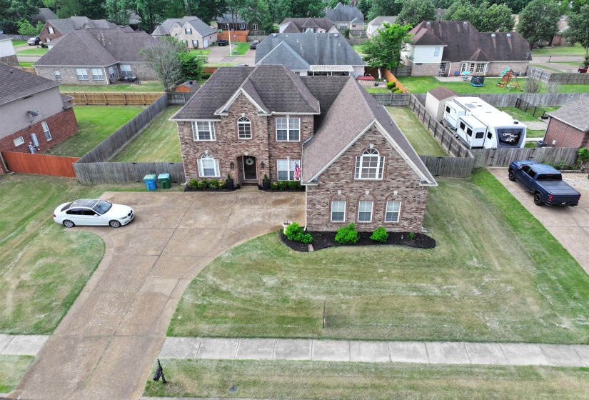 Two-story brick facade residence featuring a multi-gabled roofline and prominent front entry