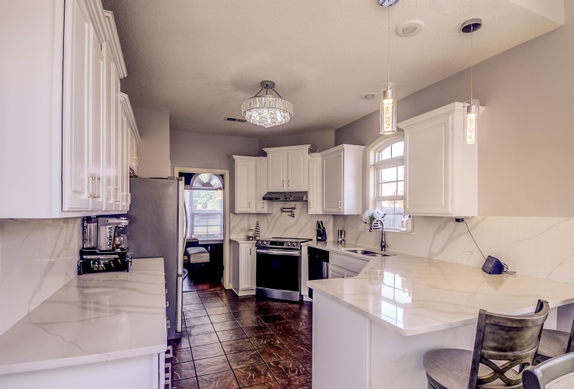 Kitchen featuring white cabinetry and light-toned countertops