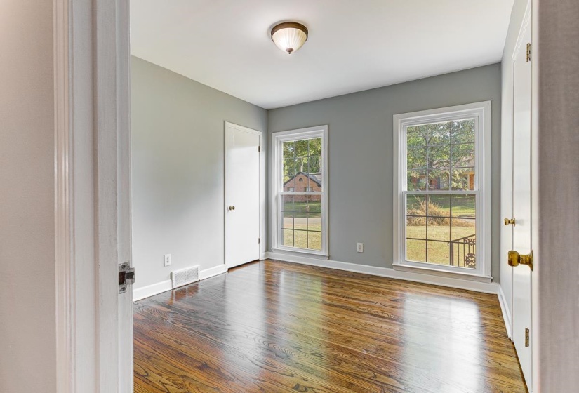 Refinished wood-finish flooring with dual windows providing natural light