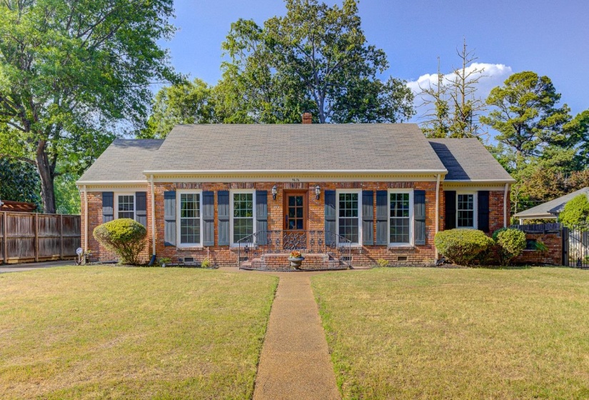 Brick exterior with a gabled roofline, featuring dark shutters and white-framed windows