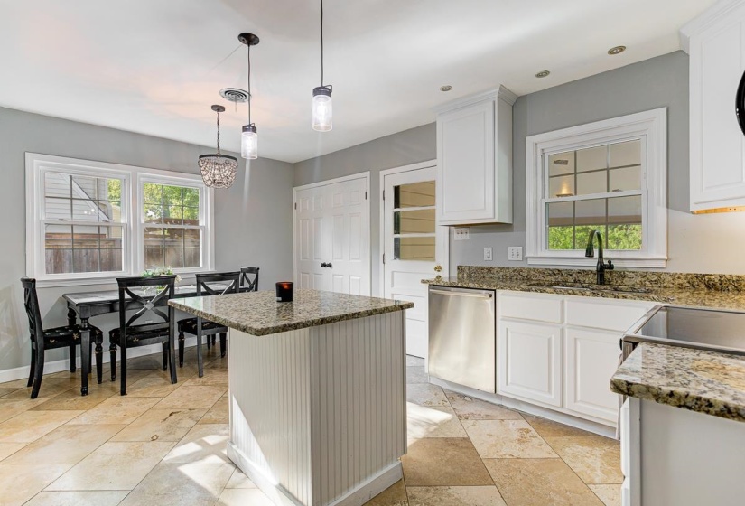 Kitchen featuring a central island with beadboard paneling and granite countertop, access to carport