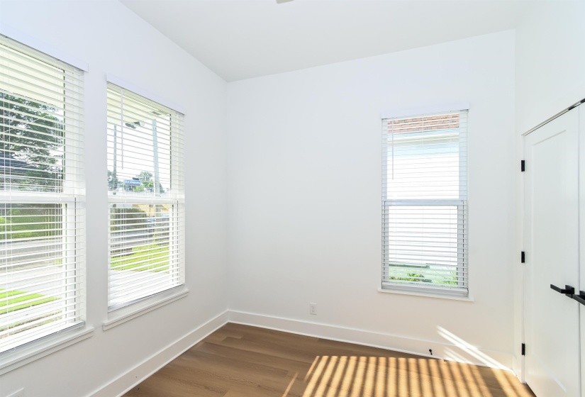 Bright interior space featuring wood-finish flooring and crisp white walls