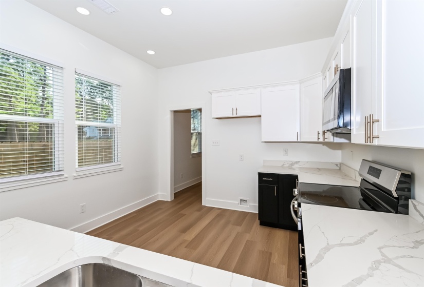 Modern kitchen featuring white shaker cabinetry, stainless steel appliances, and light-toned countertops