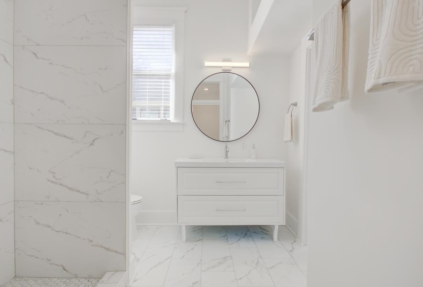 Bathroom with vanity and light marble finish floors