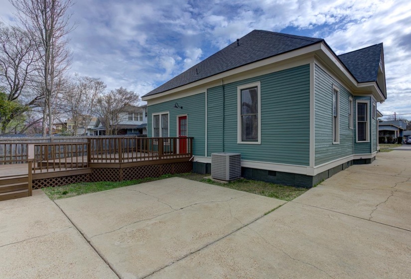 Back of property featuring crawl space, roof with shingles, a wooden deck, and a patio area