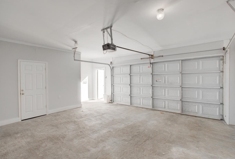 Garage featuring baseboards and a garage door opener