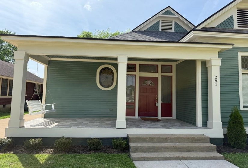 Entrance to property with covered porch and a shingled roof