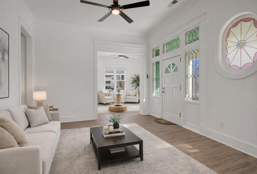Living area featuring wood finished floors, ceiling fan, and ornamental molding