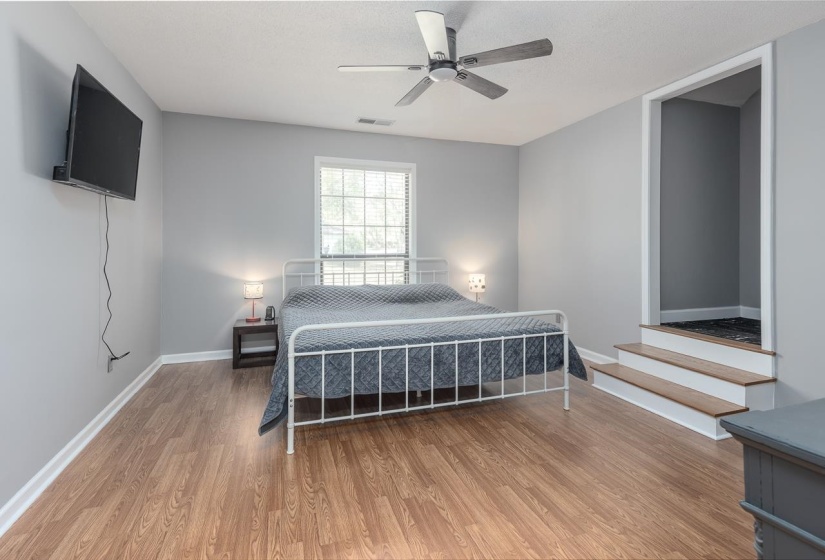 Bedroom featuring light wood-type flooring, a ceiling fan, and a textured ceiling