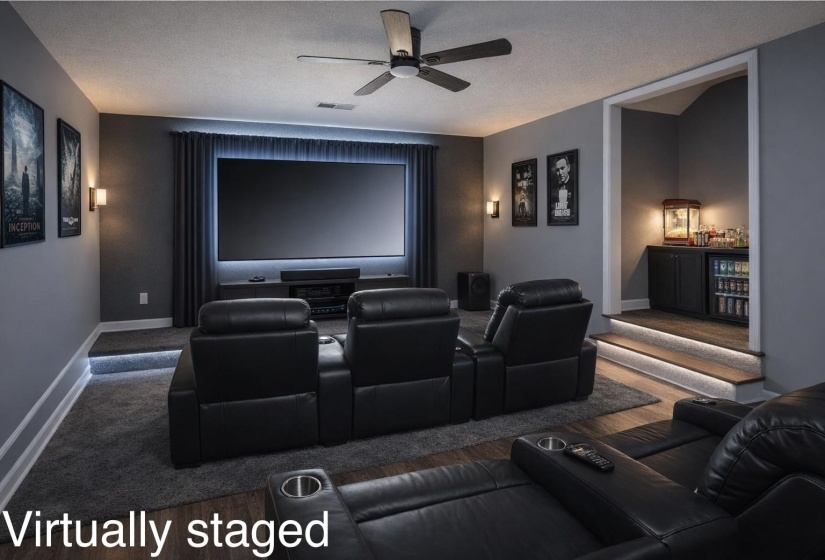 Dedicated media room (currently being used as the primary bedroom) featuring a large projection screen with backlighting, tiered seating, a built-in wet bar with beverage cooler, ceiling fan, and wall sconces