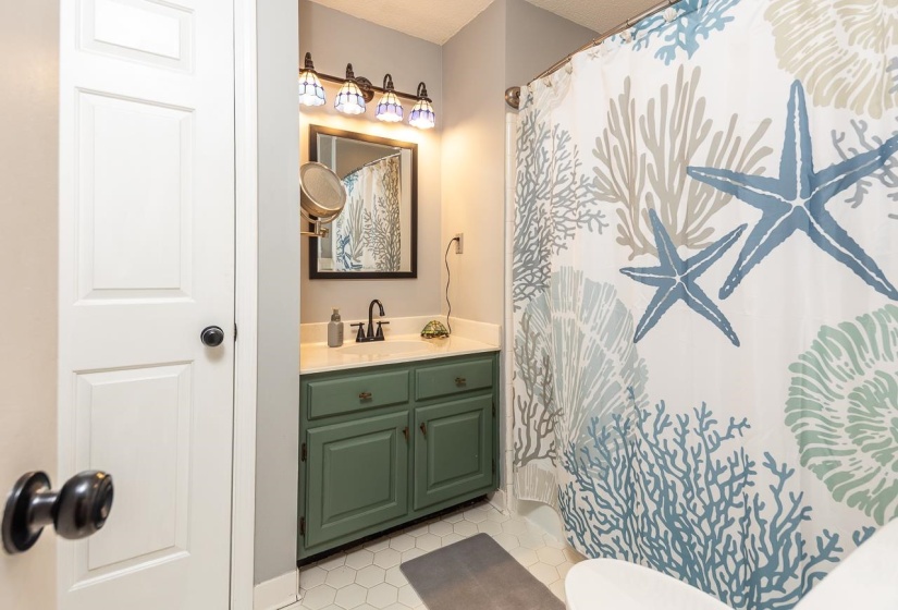 Bathroom featuring vanity, light tile patterned floors, and curtained shower