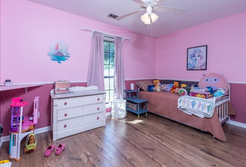 Bedroom with a textured ceiling, hardwood / wood-style floors, and ceiling fan