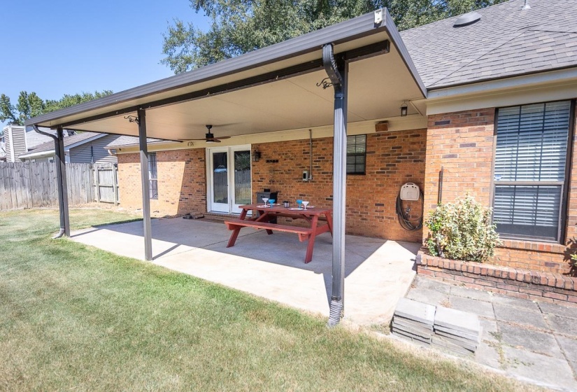 Rear view of house with a patio, brick siding, and a shingled roof