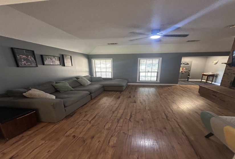 Living area with hardwood / wood-style flooring, lofted ceiling, and a ceiling fan