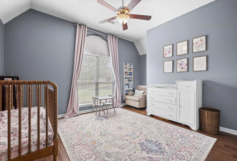 Spacious room featuring a vaulted ceiling and a ceiling fan with light fixture