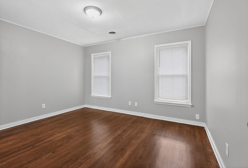 Spare room featuring dark wood-type flooring and ornamental molding