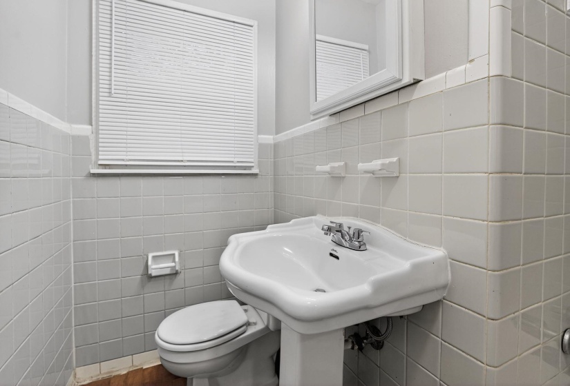 Bathroom with tile walls and a wainscoted wall
