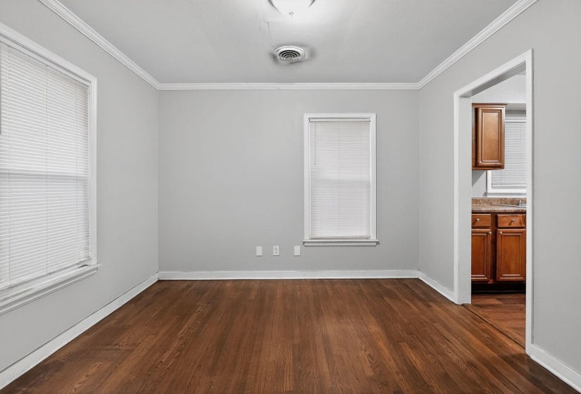 Empty room with dark wood-style flooring and crown molding