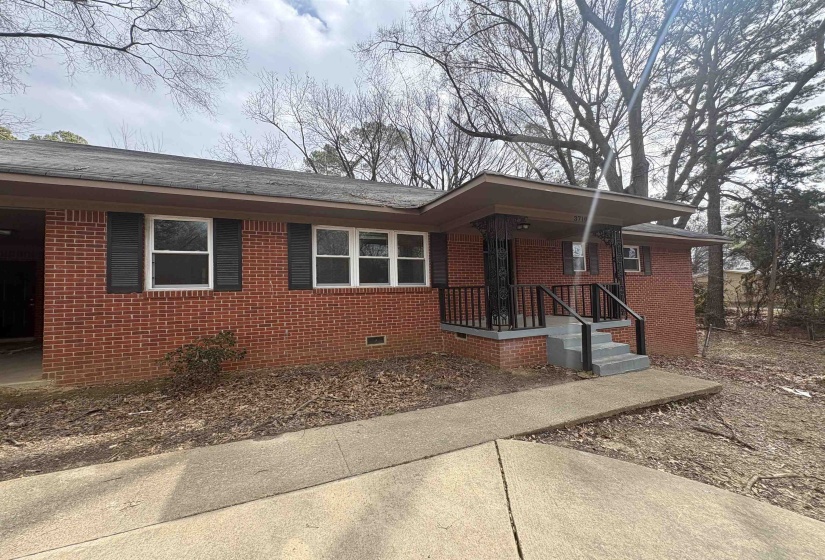View of front of home with crawl space, brick siding, and a porch