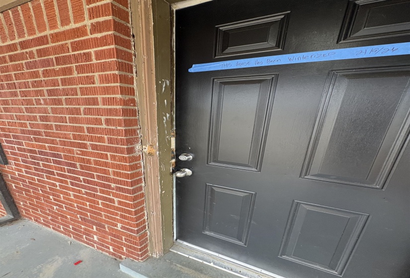 Property entrance featuring brick siding