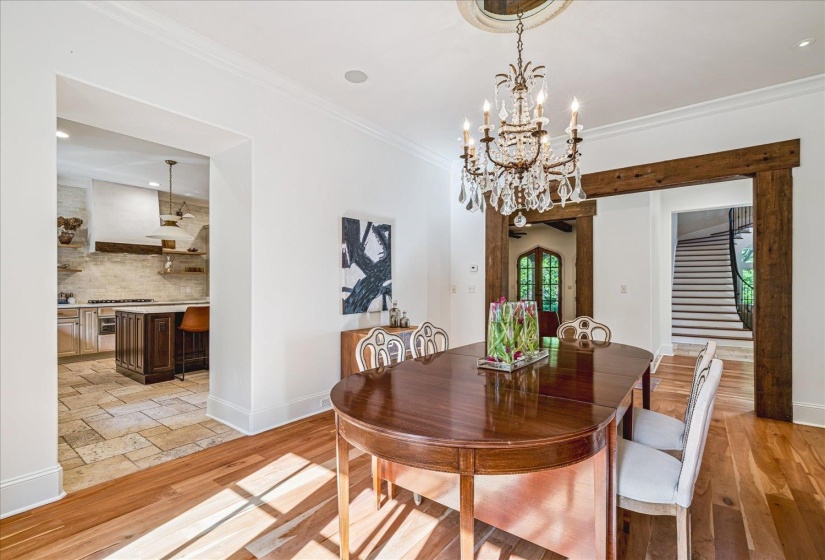 Open concept dining room featuring wood-finish flooring, a crystal chandelier, and a decorative ceiling medallion